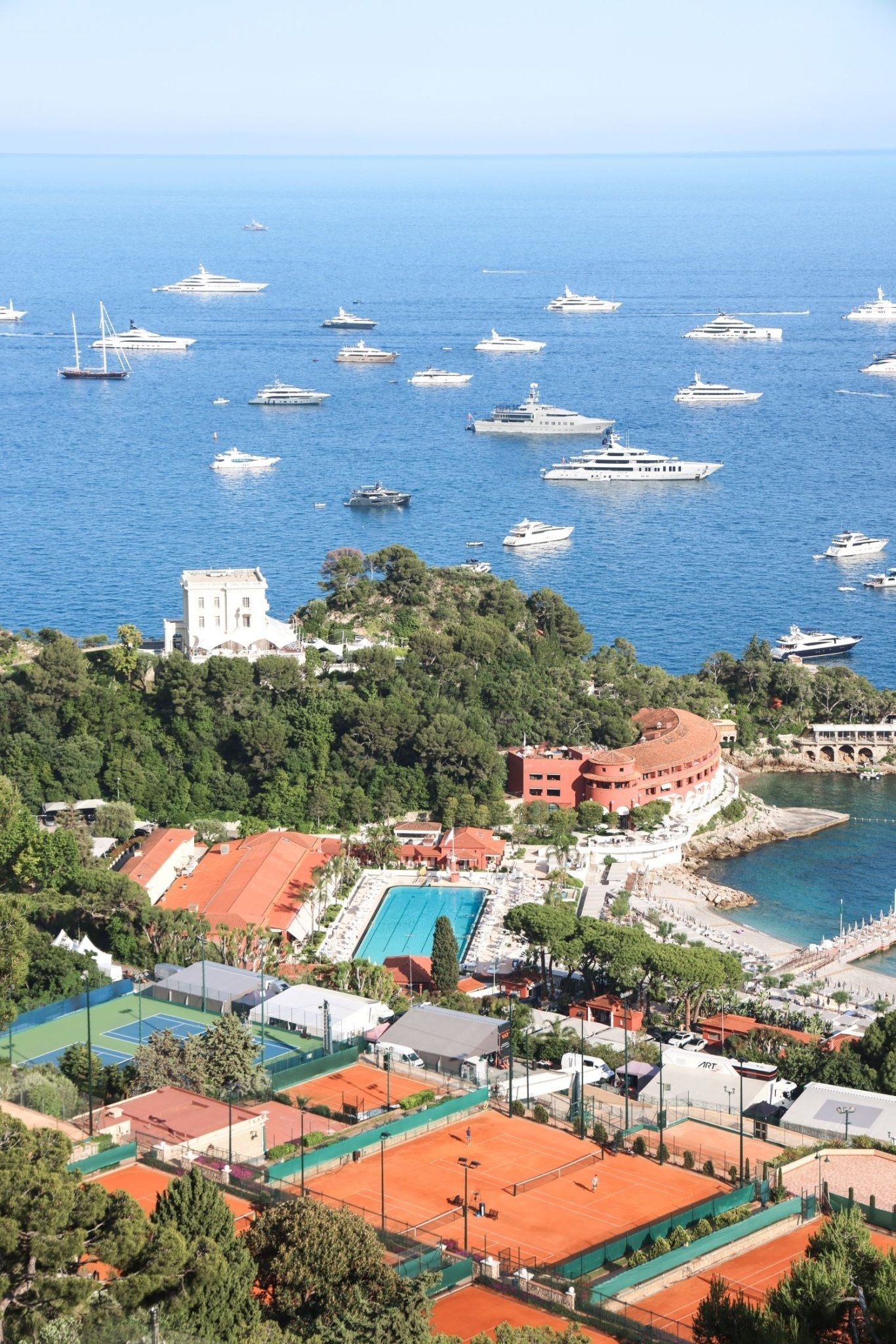 Aerial view of Monte Carlo Beach Club and clay courts, showcasing yachts on the water, representing Monaco Print.