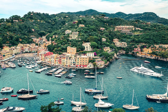 Portofino Print showing a wide angled view of the harbour filled with fishing vessels and superyachts.