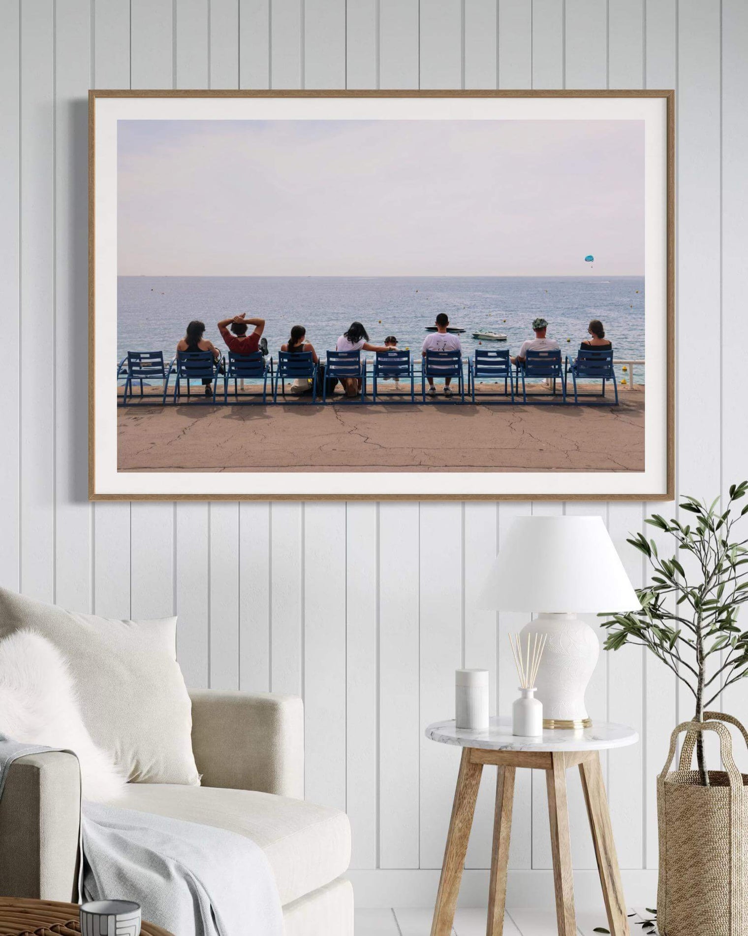 People sitting on blue chairs along the beach at La Promenade des Anglais in Nice Print.
