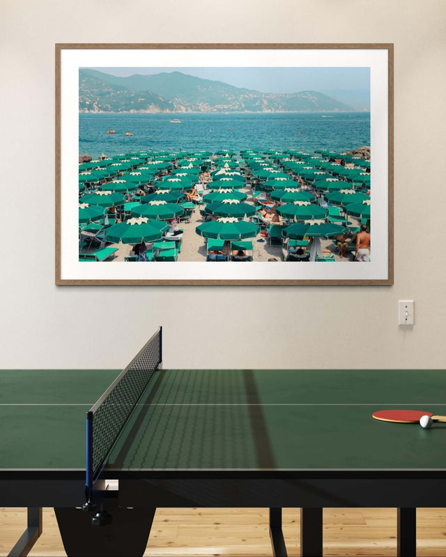 Italian Beach Print featuring vibrant green parasols on a sunny beach with blue water and the Italian coastline.