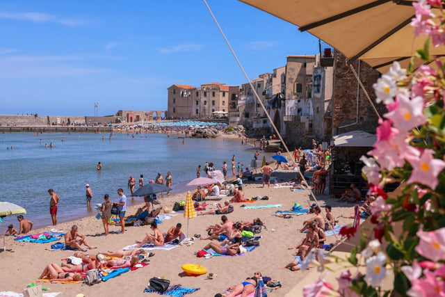 Italian beach print featuring the scenic Spiaggia di Cefalù with sunbathers and vibrant seaside life.